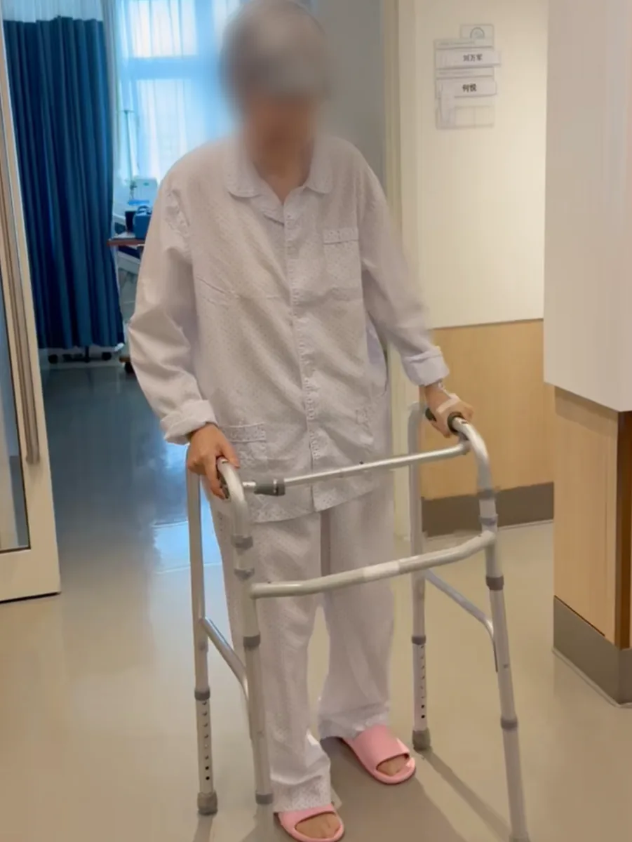 An elderly patient walking with a walker during post-operative rehabilitation at Jiahui International Hospital