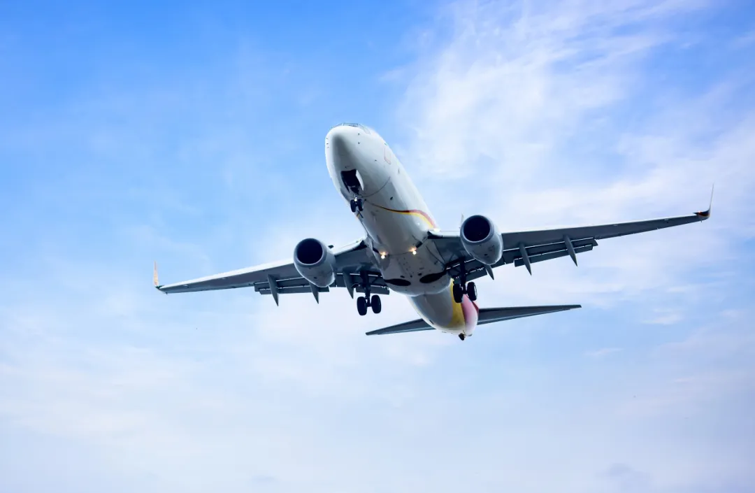 An aircraft in flight, representing the 9,000-kilometer journey from New Zealand to Shanghai for CAR-T treatment