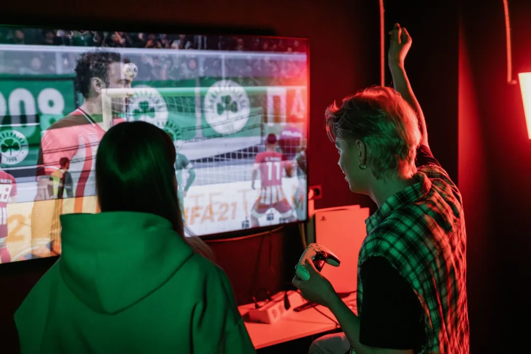 Two people playing video games, illustrating sedentary summer habits that can worsen men's health