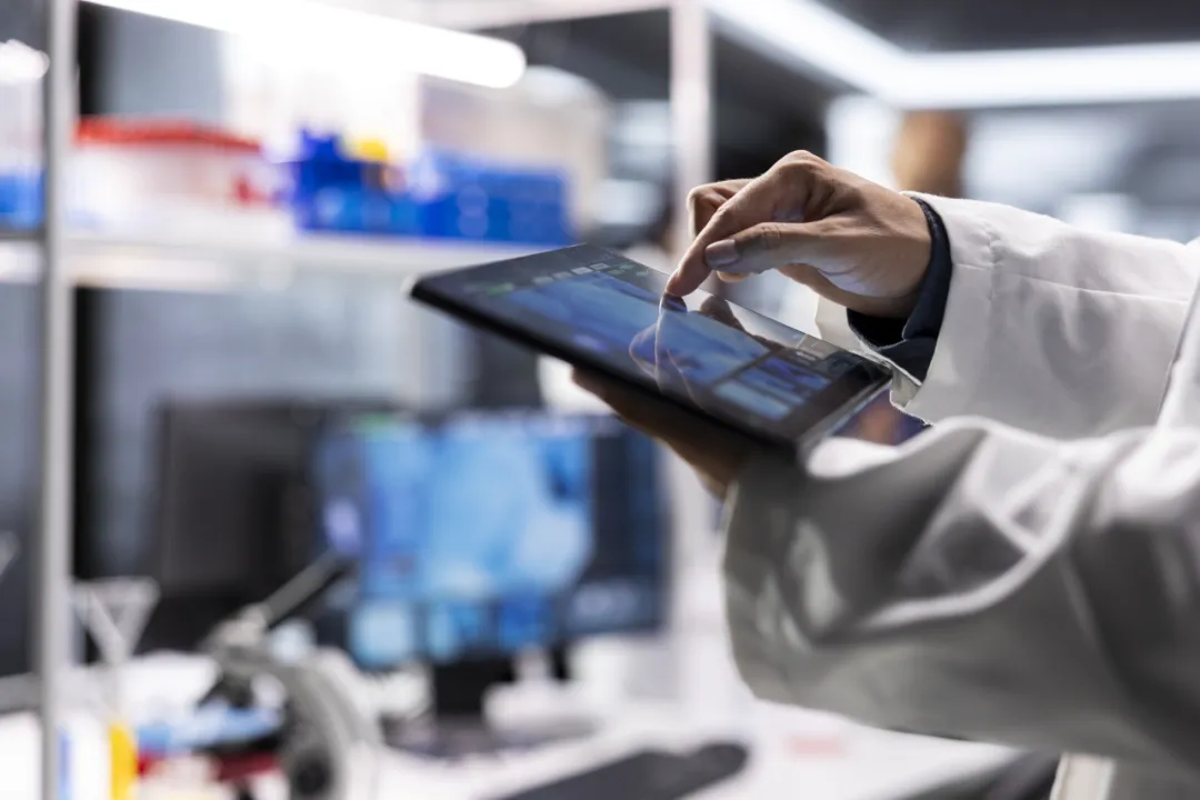Clinician reviewing medical data on a tablet in a modern oncology center
